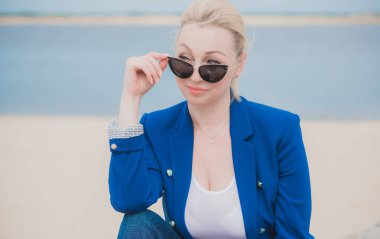 Modern iş kadınının portresi her hafta plajda dinleniyor. 