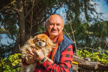 Kırmızı küçük köpeği olan yaşlı bir adam emekli, yaşlı insanların yaşam tarzı.