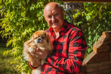 Kırmızı küçük köpeği olan yaşlı bir adam emekli, yaşlı insanların yaşam tarzı.