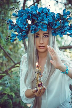 Bride making magic of candles, magical attributes, herbs and flowers, Slavic/ Wicca rituals and esoteric concept