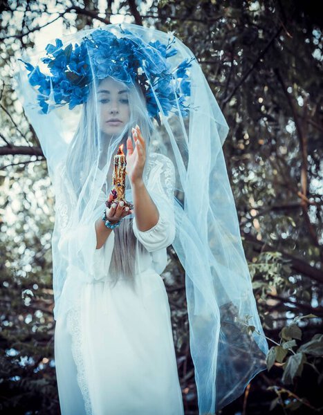 Bride making magic of candles, magical attributes, herbs and flowers, Slavic/ Wicca rituals and esoteric concept