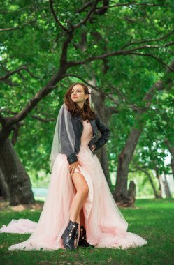 Pembe pastel gelinlik içinde zarif genç gelin, şık bir koleksiyon.