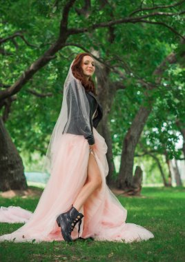 Pembe pastel gelinlik içinde zarif genç gelin, şık bir koleksiyon.