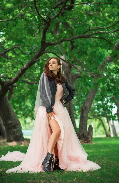 Pembe pastel gelinlik içinde zarif genç gelin, şık bir koleksiyon.