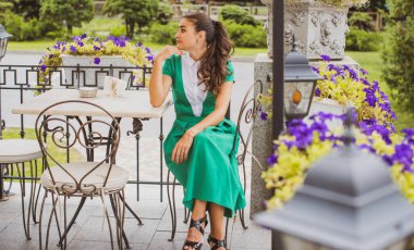 Doğa, yaz tatili, tatil ve insanların konsepti. Parktaki genç Arap kadın iyi bir hayat düşlüyor ve anın tadını çıkarıyor.