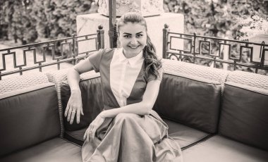 Doğa, yaz tatili, tatil ve insanların konsepti. Parktaki genç Arap kadın iyi bir hayat düşlüyor ve anın tadını çıkarıyor.