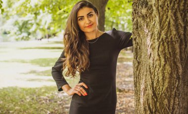 Doğa, yaz tatili, tatil ve insanların konsepti. Parktaki genç Arap kadın iyi bir hayat düşlüyor ve anın tadını çıkarıyor.