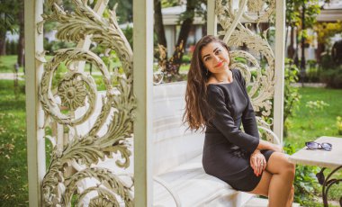 Doğa, yaz tatili, tatil ve insanların konsepti. Parktaki genç Arap kadın iyi bir hayat düşlüyor ve anın tadını çıkarıyor.