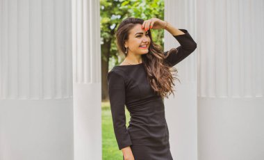 Doğa, yaz tatili, tatil ve insanların konsepti. Parktaki genç Arap kadın iyi bir hayat düşlüyor ve anın tadını çıkarıyor.