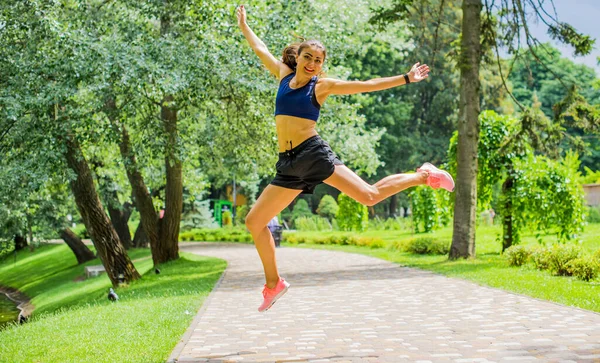 緑豊かな緑の都市公園で外で行使美しいブルネットの女性のフィットネスの女の子 公園でスポーツトップジョギングの女性 健康的な女の子のライフスタイルの背景とともにコピースペース — ストック写真