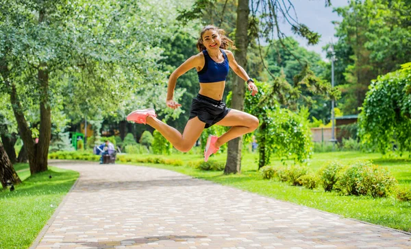 緑豊かな緑の都市公園で外で行使美しいブルネットの女性のフィットネスの女の子 公園でスポーツトップジョギングの女性 健康的な女の子のライフスタイルの背景とともにコピースペース — ストック写真