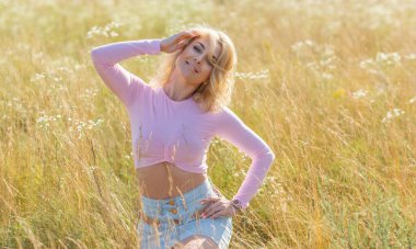 Pembe bluz ve etekli sarışın romantik kadın, güzel bayan kıyafeti, çayırdaki kız.