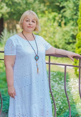 Güzel güneşli bir günde, sıradan tarzda yürüyen çekici ve olgun bir kadının portresi. 40-50 yıl sonra kadın hayatı