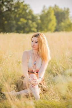 Klasik Boho tarzı, günbatımında hippi tarzı bir kız, şık kıyafetler ve detaylar..