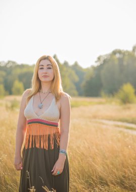Klasik Boho tarzı, günbatımında hippi tarzı bir kız, şık kıyafetler ve detaylar..