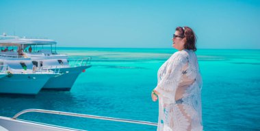 Tombul orta yaşlı kadın yatta dinleniyor, olgun kadınlar için yaşam tarzı, büyük beden kıyafetler. 