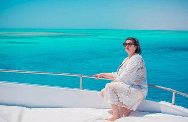 Tombul orta yaşlı kadın yatta dinleniyor, olgun kadınlar için yaşam tarzı, büyük beden kıyafetler. 