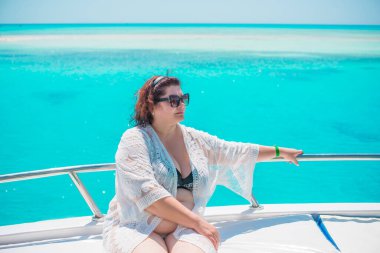 Tombul orta yaşlı kadın yatta dinleniyor, olgun kadınlar için yaşam tarzı, büyük beden kıyafetler. 