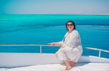 Tombul orta yaşlı kadın yatta dinleniyor, olgun kadınlar için yaşam tarzı, büyük beden kıyafetler. 