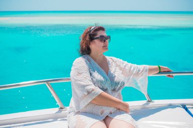 Tombul orta yaşlı kadın yatta dinleniyor, olgun kadınlar için yaşam tarzı, büyük beden kıyafetler. 