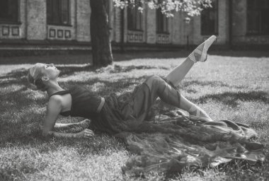 Klasik görünümlü genç balerin. Bale dansçısı kız. Dans eden bir kadının görüntüsü. Mor gece elbisesi içindeki kadın kadınlığını gösterdi. Klasik Koreografi Biçimi