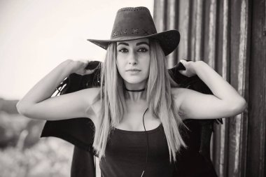 Amerikan tarzı kovboy şapkalı siyah boho ceketli bir kız.