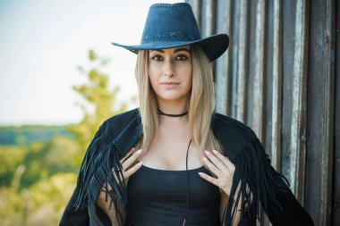 Amerikan tarzı kovboy şapkalı siyah boho ceketli bir kız.