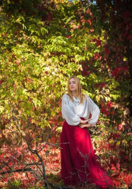 Sonbahar koleksiyonu, beyaz gömlekli kadın ve uzun bordo etekli kadın. Açık havada portre