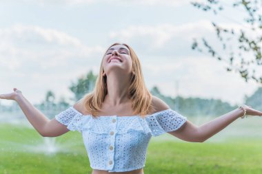 Beyaz pamuklu takım elbiseli kadın, etek ve etek doğada, tatil sahnesi.