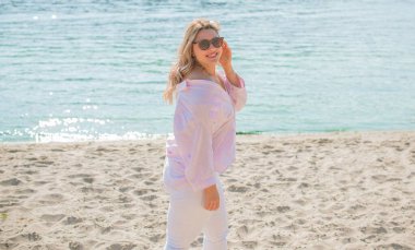 Artı plajda Avrupalı sarışın bir kadın, tatilde, hayatın tadını çıkarıyor, yürüyor. İnsanların hayatı XI boyutunda, mutlu doğal güzel bir bayan. Aşırı kilolu kavramı