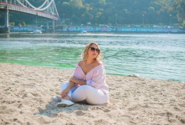 Artı plajda Avrupalı sarışın bir kadın, tatilde, hayatın tadını çıkarıyor, yürüyor. İnsanların hayatı XI boyutunda, mutlu doğal güzel bir bayan. Aşırı kilolu kavramı