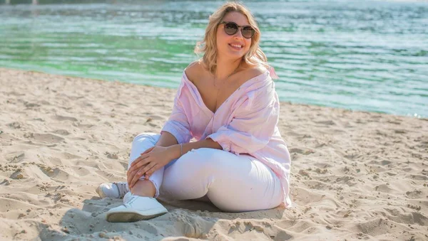 Artı plajda Avrupalı sarışın bir kadın, tatilde, hayatın tadını çıkarıyor, yürüyor. İnsanların hayatı XI boyutunda, mutlu doğal güzel bir bayan. Aşırı kilolu kavramı