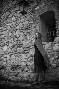 Cadılar Bayramı kavramı. Küçük kırmızı başlıklı güzel ve basit bir kostüm. Sisli ormandaki gizemli kukuletalı figür. Kırmızı yağmurluklu kız. Kostümlü Masal Kırmızı Başlıklı Kız