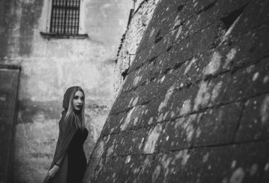 Cadılar Bayramı kavramı. Küçük kırmızı başlıklı güzel ve basit bir kostüm. Sisli ormandaki gizemli kukuletalı figür. Kırmızı yağmurluklu kız. Kostümlü Masal Kırmızı Başlıklı Kız