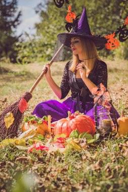 Cadılar Bayramı cadısı Mistik atmosferdeki kadın balkabağıyla dışarıda sonbaharı kutluyor.