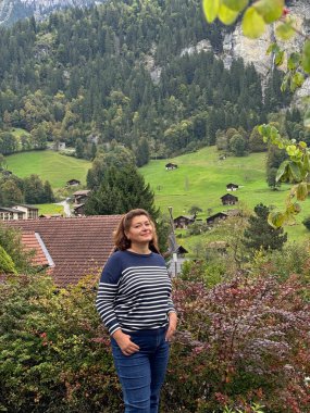 Orta yaşlı bayan İsviçre Alplerinde geziyor ve Alp maceralarının tadını çıkarıyor.