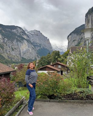 Orta yaşlı bayan İsviçre Alplerinde geziyor ve Alp maceralarının tadını çıkarıyor.
