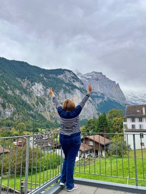 Orta yaşlı bayan İsviçre Alplerinde geziyor ve Alp maceralarının tadını çıkarıyor.