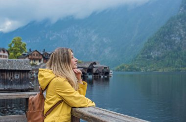 Sarı Ceketli Kadın Hallstatt Gölü, Avusturya 'ya hayran. Alp Köyünde Seyahat ve Turizm Konsepti