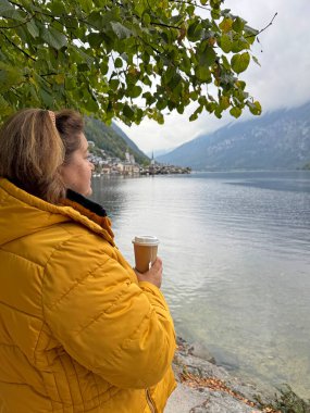 Avrupa 'da Olgun Kadın. Sonbahar Yaşam Tarzı Konsepti. Kalın sonbahar kıyafetleri giymiş şık, kilolu bir bayan, günlük kıyafetler. Yaşam tarzı ve seyahat konsepti vücut pozitifliği, kendine güven gösteriyor
