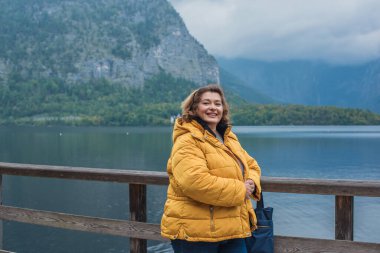 Avrupa 'da Olgun Kadın. Sonbahar Yaşam Tarzı Konsepti. Kalın sonbahar kıyafetleri giymiş şık, kilolu bir bayan, günlük kıyafetler. Yaşam tarzı ve seyahat konsepti vücut pozitifliği, kendine güven gösteriyor