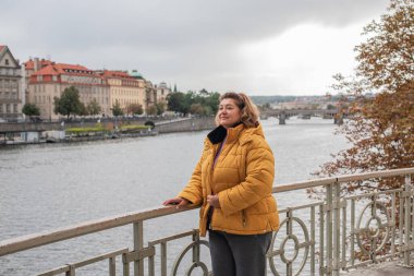 Avrupa 'da Olgun Kadın. Sonbahar Yaşam Tarzı Konsepti. Kalın sonbahar kıyafetleri giymiş şık, kilolu bir bayan, günlük kıyafetler. Yaşam tarzı ve seyahat konsepti vücut pozitifliği, kendine güven gösteriyor
