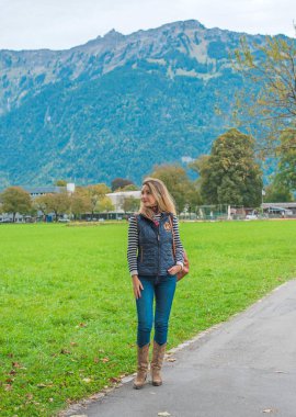 Sıradan kovboy kıyafetli Avrupalı bir kadın. İsviçre dağları ve manzaraları