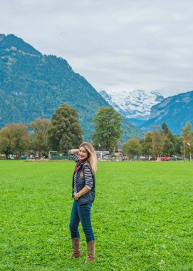 Sıradan kovboy kıyafetli Avrupalı bir kadın. İsviçre dağları ve manzaraları
