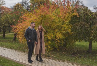 Zarif Avrupalı çift, şehir sokaklarında birlikte yürüyor. Ilık sonbahar ışığı, nazik gülümsemeler ve sinematik klasik atmosfer.