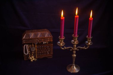 Mum ışığında hazine, eski ahşap bir kutuda masanın üstünde.