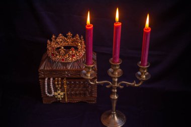 Mum ışığında hazine, eski ahşap bir kutuda masanın üstünde.