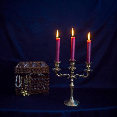 Mum ışığında hazine, eski ahşap bir kutuda masanın üstünde.