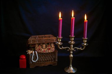 Mum ışığında hazine, eski ahşap bir kutuda masanın üstünde.