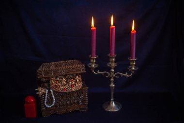 Mum ışığında hazine, eski ahşap bir kutuda masanın üstünde.